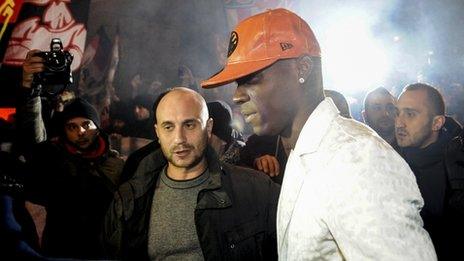 Mario Balotelli looks at fans near a restaurant in Milan. Photo: 30 January 2013