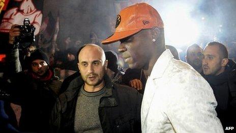 Mario Balotelli looks at fans near a restaurant in Milan. Photo: 30 January 2013