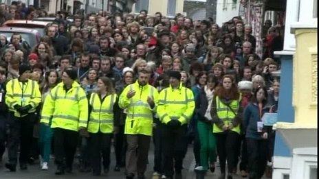 Theatrical production and audience follow the protesters' route