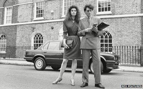 A 1980s couple pose in front of house and car