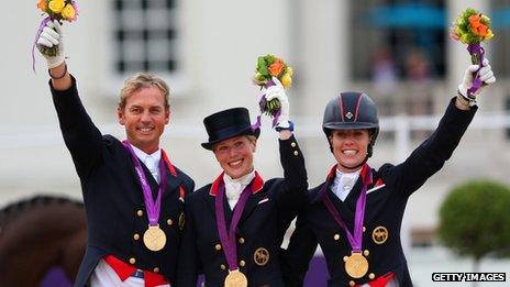 Carol Hester, Laura Bechtolsheimer and Charlotte Dujardin of Team GB celebrate with their gold medals