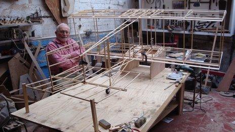 Merlin Maddock in his workshop with a scale model of Carlyon's glider