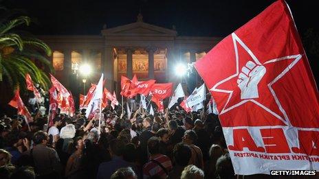 (File photo) Syriza party members wave flags outside a rally