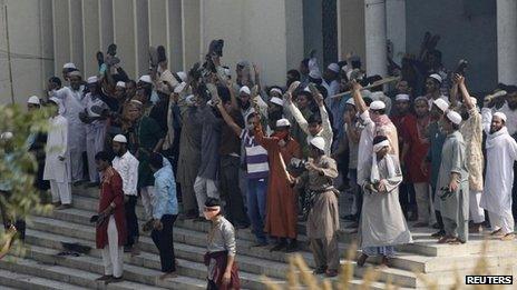 Activists from 12 Islamist parties stand at the entrance to the national mosque during a clash with the police