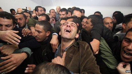 Palestinian relatives and friends mourn Arafat Jaradat, who died in an Israeli prison, after his body was handed over by Israeli authorities on Sunday at a hospital in the West Bank city of Hebron