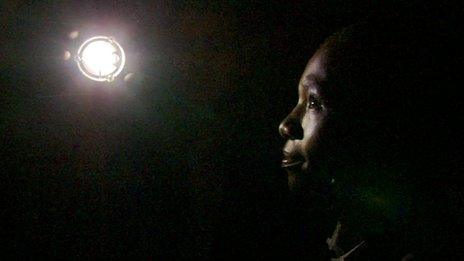 Student holding solar lamp