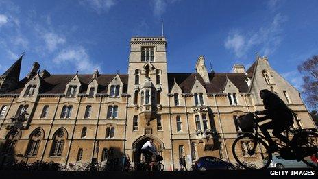 A woman cycles past Balliol College in Oxford