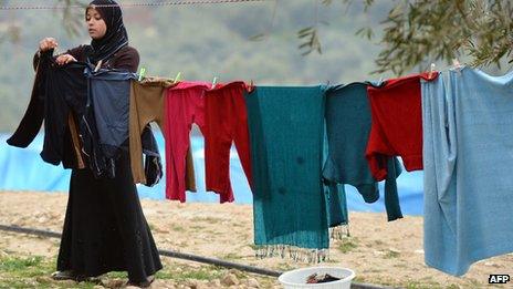 A displaced Syrian refugee her washed clothes at the refugee camp of Qah along the Turkish border in the village of Atme in the northwestern province of Idlib, on January 31 2012.