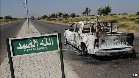 A burnt police patrol pick-up truck remains abandoned on the side of a deserted road in Damaturu in Nigeria on 7 November 2011 after having been struck by a bomb