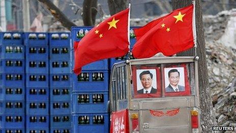 Portraits of Chinese President Hu Jintao (L) and Premier Wen Jiabao are displayed on a tricycle at a demolished residential site where new skyscrapers will be built in Beijing, 18 February 2013