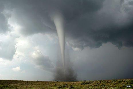 A tornado tears across a field