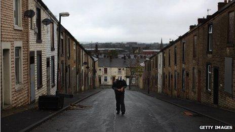 An unemployed youth walks through a street in Accrington, Lancashire