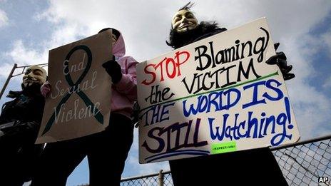 Protesters, who did not want to be identified, hold signs outside of the Jefferson County Justice Center and Jail in Steubenville, Ohio, on 13 March 2013