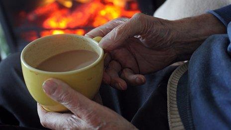 Old man holding cup of tea