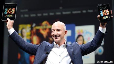 Jeff Bezos holds up the larger Kindle Fire tablet