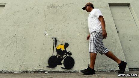 Los Angeles graffiti depicting a cyclist in a yellow jersey, the traditional garb of a Tour de France winner, attached to an IV drip.