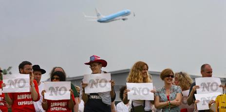 Protesters hold up "NO" signs outside Heathrow