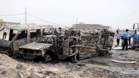 Iraqi police examine the wreckage after the deadly car bomb near Basra