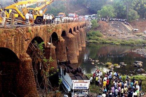 Rescuers and others gather at the site of a bus accident in Ratnagiri district, in the western Indian state of Maharashtra, Tuesday, March 19, 2013