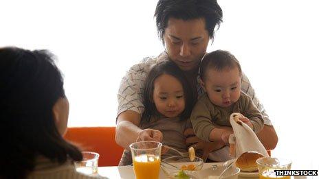 Father helping feed children