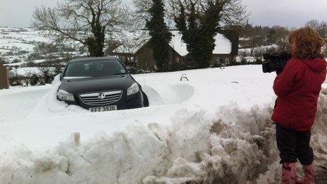 Reporter films car in snow drift