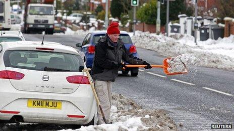 Man clears snow from his car in North Belfast