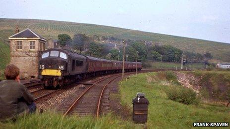 At lonely Riccarton Junction in a late afternoon of spring 1966, ‘Peak’ Type 4 class battles up the 1 in 75 towards Whitrope Summit with the daily service conveying through coaches from St Pancras. Latterly the only passenger services which did not call at Riccarton – which depended on trains for its public transport – were this daytime London train, its southbound equivalent, the night trains in each direction and the seasonal service between Dundee and Blackpool North. The first signs of growth of the Forestry Commission plantations around Riccarton can be seen in the background; sadly – and perhaps crucially – despite inconsistent efforts by BR, no timber moved on the Waverley Route in the 1960s.