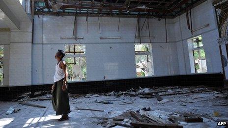 A man walks in a mosque destroyed after communal violence in central Burma (28 March 2013)