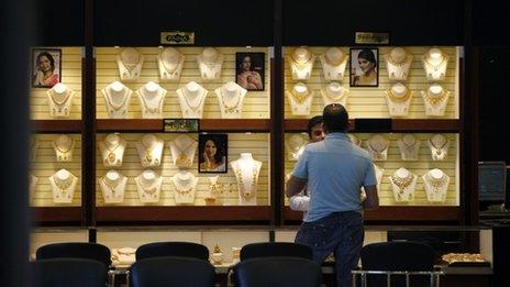 An Indian sales man attends to a customer at a jewelry store in Bangalore, India, Thursday, Feb. 28, 2013. In