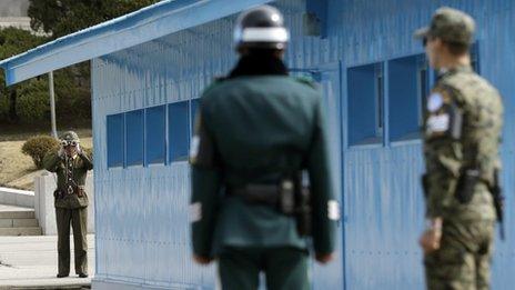 A North Korean soldier (left) looks through binoculars at South Korean soldiers at the border village of Panmunjom. Photo: March 2013