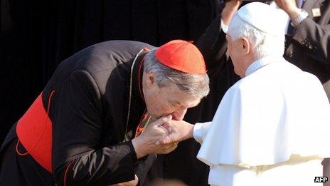 File photo (July 2008) of Australia's Cardinal George Pell (left) kissing the hand of Pope Benedict XVI