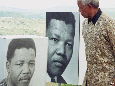 Mr Mandela passing portraits of himself in his youth, at the opening of a museum, Friday February 11 2000 in Mvezo, Eastern Cape (right)