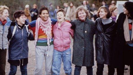 Women locking arms and singing at Greenham Common