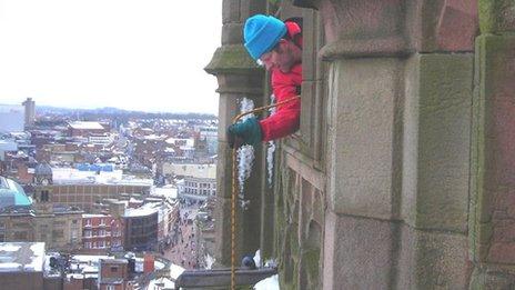 A member of the trust lowers the hot water bottle towards the nest from the tower at Derby Cathedral.