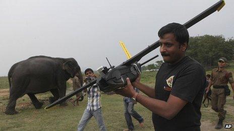 A WWF official carries a drone before flying it at the Kaziranga National Park in Assam on Monday, April 8, 2013