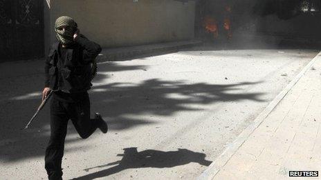 A fighter from Jabhat al-Nusra runs as the group's base is shelled in Raqqa province, eastern Syria, in March 14, 2013