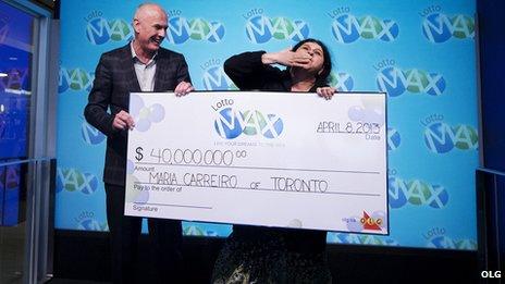 Greg McKenzie, VP of Lottery at OLG, presents a cheque for $40 million to Maria Carreiro 8 April 2013