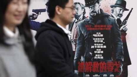 People walk past a Django Unchained poster in Beijing