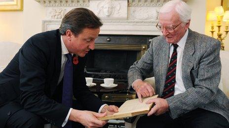 Leslie Valentine showing Prime Minister David Cameron the entry on the smoke laying operation in his pilot log book