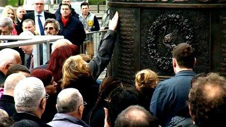 Families touch the Hillsborough Memorial