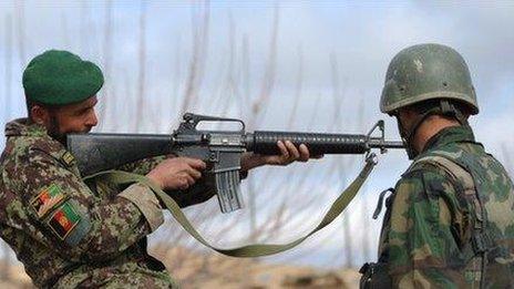 An Afghanistan National Army soldier checks a weapon in Helmand