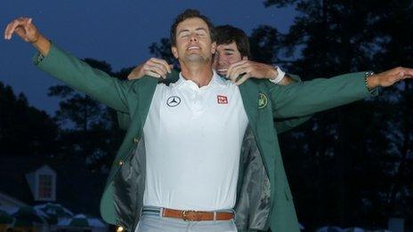 Adam Scott of Australia (left) receives his green jacket from 2012 champion Bubba Watson