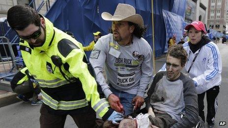 Medics help an injured man, named by media as Jeffrey Bauman, following an explosion in Boston, Monday, April 15, 2013