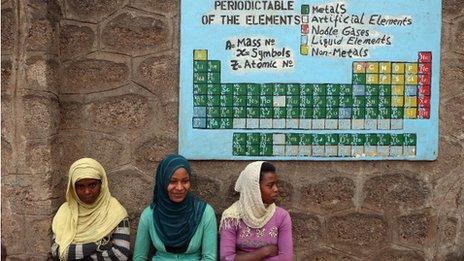 Female secondary school students sit under the periodic table of the elements in the courtyard at the AGOHELD orphanage, hospital, training centre and school, founded by Abebech Gobena, Ethiopia.