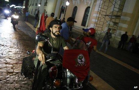 A man dressed like revolutionary Ernesto "Che" Guevara rides his motorcycle as he arrives at a gathering in support of Nicolas Maduro in Caracas, 16 April