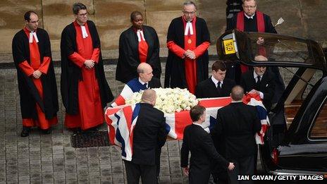 The coffin is transferred to the hearse