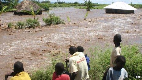 Residents of Kano plains look on 14 April 2013 at one of the homes that was submerged by floodwaters after the Nyando river burst its banks, displacing families in the area and forcing most to move to higher ground for safety