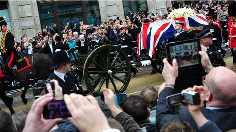 Those in the crowds struggled to see the coffin cart through a sea of cameras