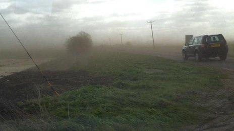 Mud blown across a road in Cambridgeshire