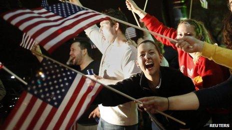 People wave US flags and cheer as police drive down Arlington Street in Watertown, Massachusetts on Friday following the capture of the second suspect in the Boston Marathon bombing, Dzhokhar Tsarnaev